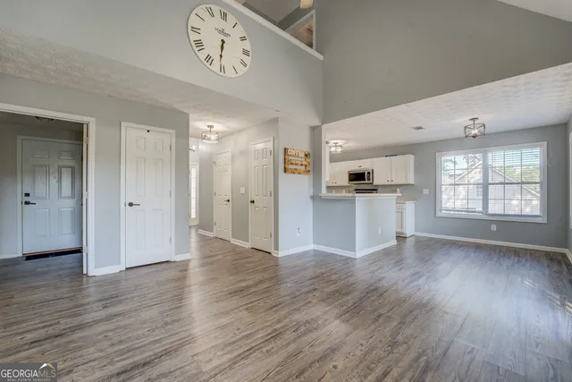 a view of an empty room with window and wooden floor