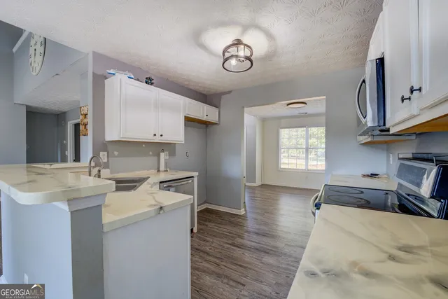 a kitchen with a sink cabinets and wooden floor