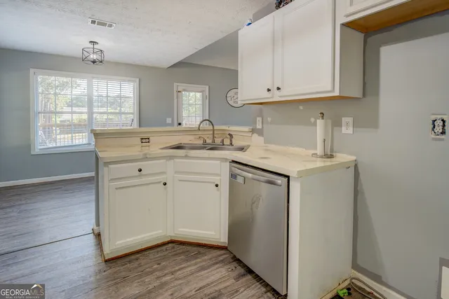 a view of cabinets a wooden floor and a window in a room