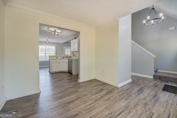 a view of a kitchen with a wooden floor and a kitchen