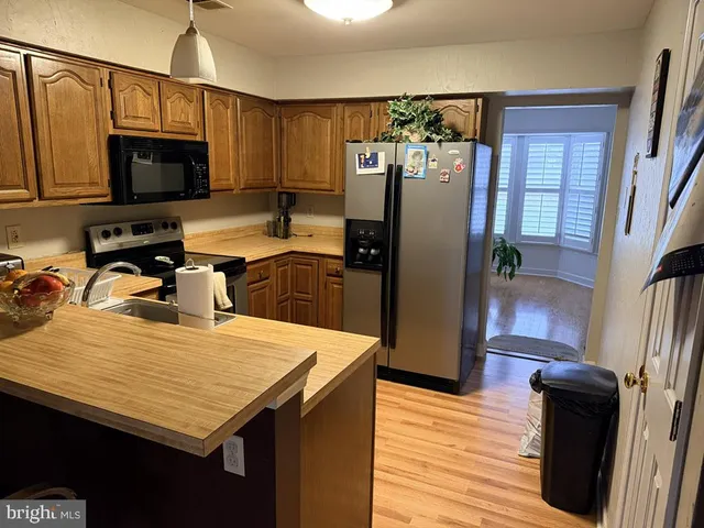 a kitchen with stainless steel appliances a refrigerator a stove a sink a microwave and cabinets