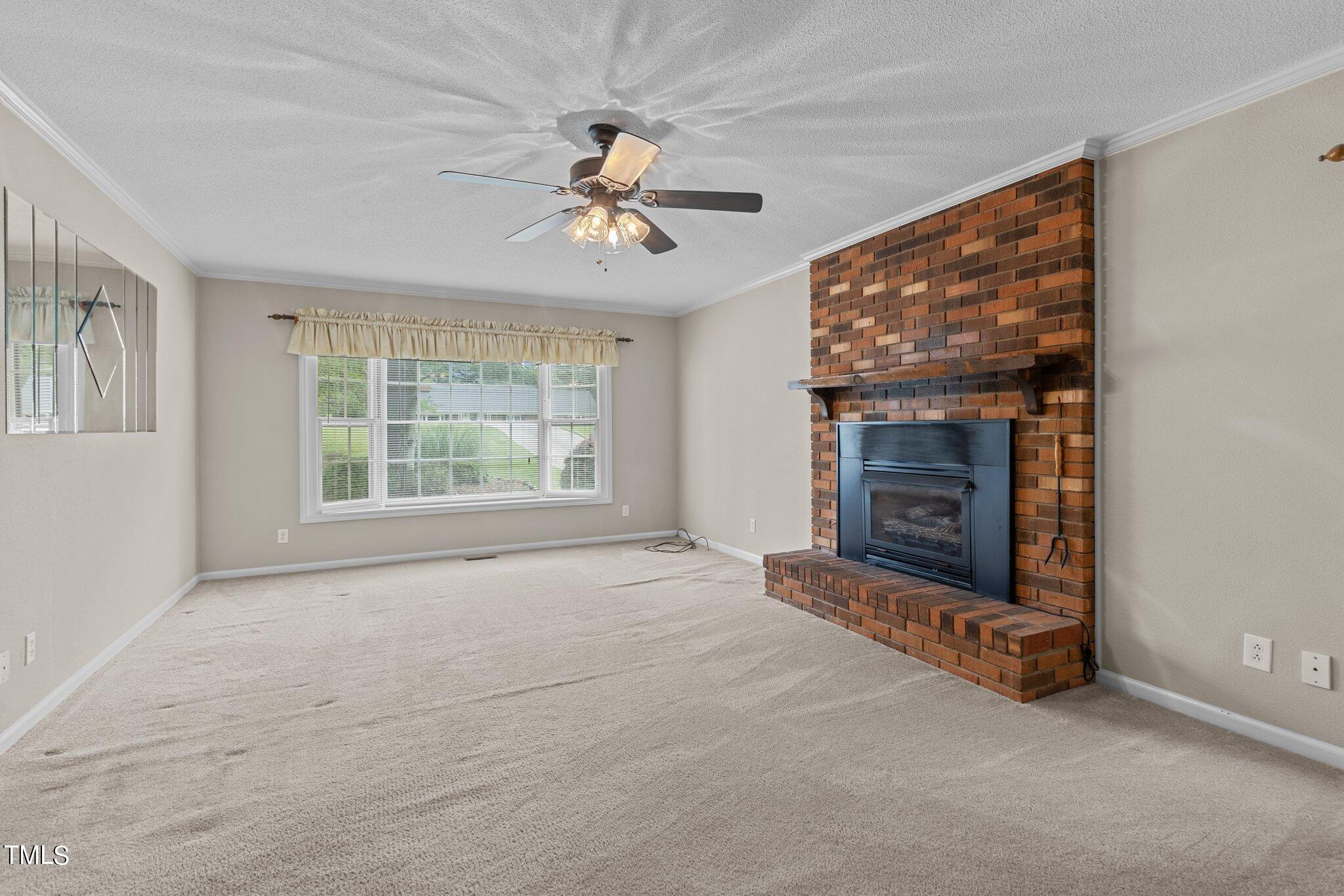 5125 Russell Road Durham, NC 27712 - Photo 21 of 59 a view of an empty room with a fireplace and a window