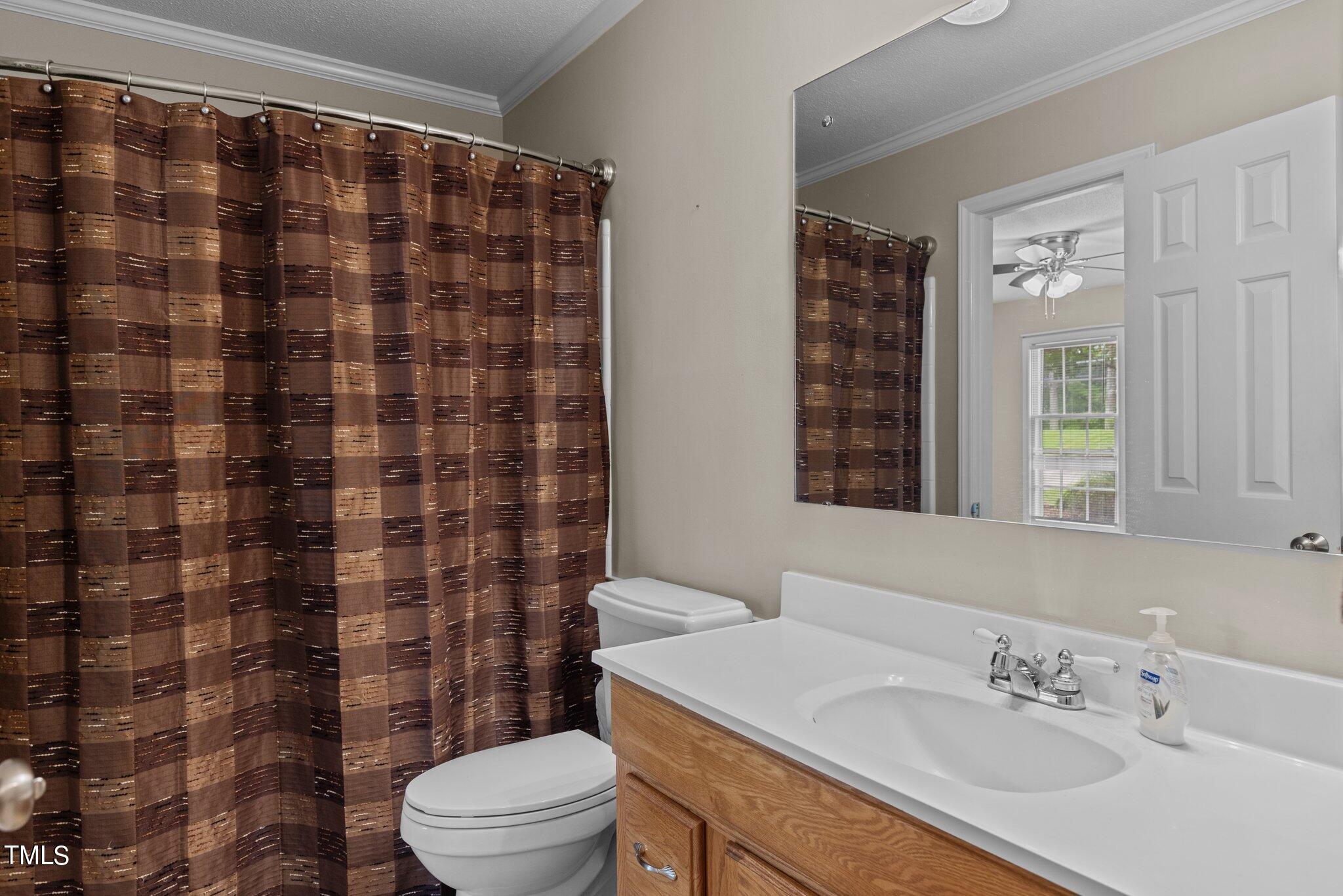 5125 Russell Road Durham, NC 27712 - Photo 30 of 59 a bathroom with a sink a toilet and shower curtain