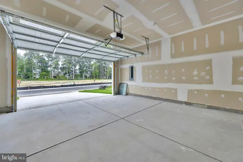 a view of an empty room with a window and chandelier