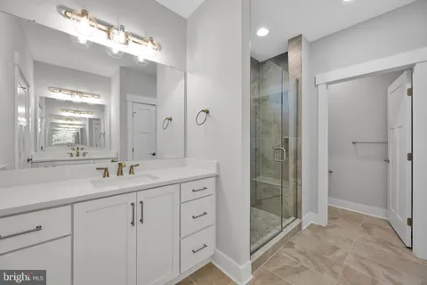 a bathroom with a double vanity sink mirror and shower