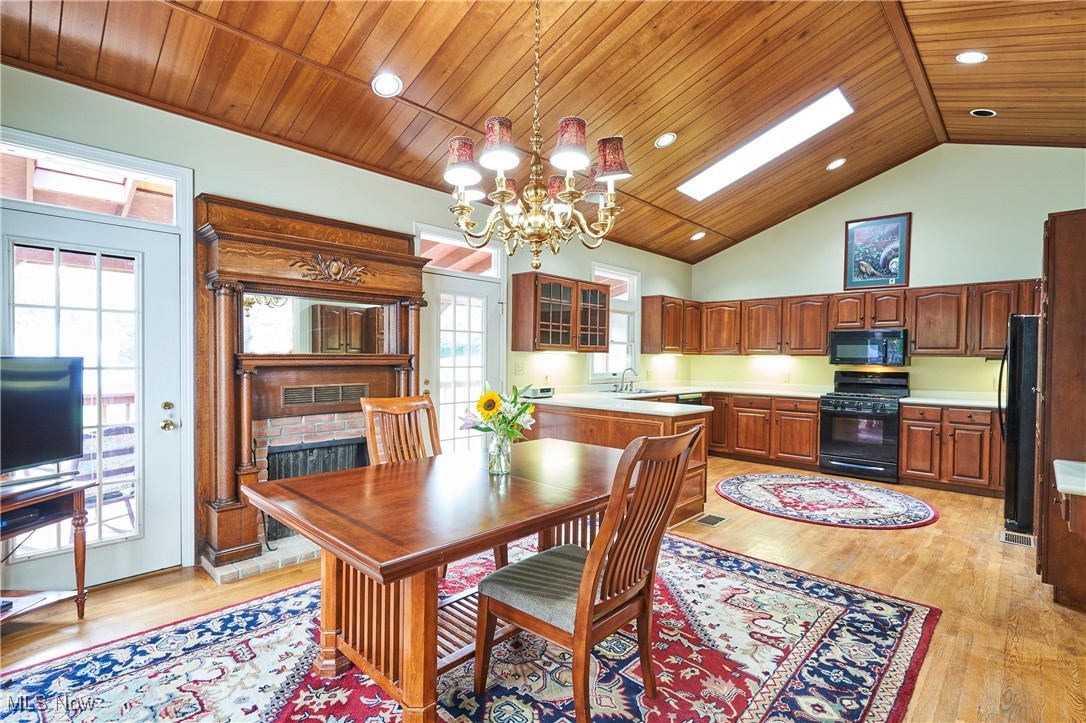2610 Shade Road Akron, OH 44333 - Photo 10 of 45 Kitchen /Dining room combined. Vaulted planked ceilings with skylights and wood floors. The dining space could also be used as a gathering room . The glass french door leads to te covered deck