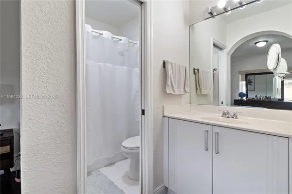 a bathroom with a double vanity sink mirror and toilet