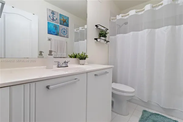 a bathroom with a sink a toilet and shower curtain