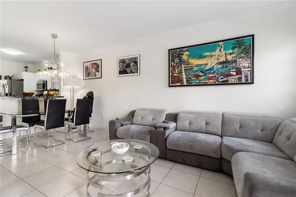 a living room with furniture a rug and kitchen view
