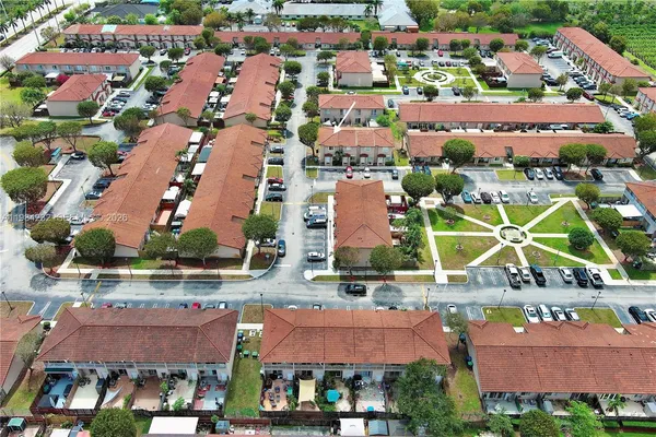 an aerial view of residential houses with outdoor space and parking