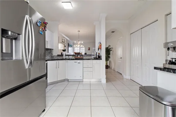 a large white kitchen with a sink and cabinets