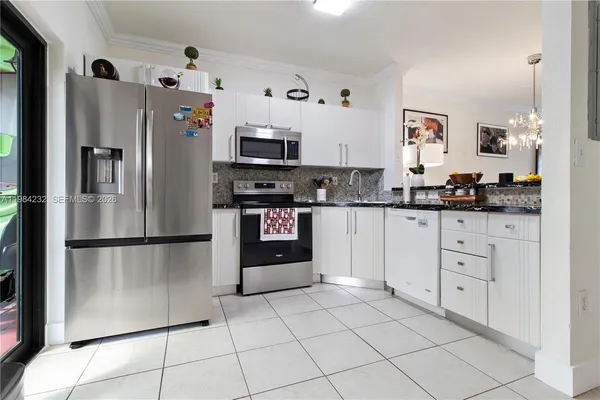 a kitchen with stainless steel appliances a refrigerator sink and microwave