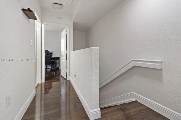 a view of hallway with stairs and wooden floor