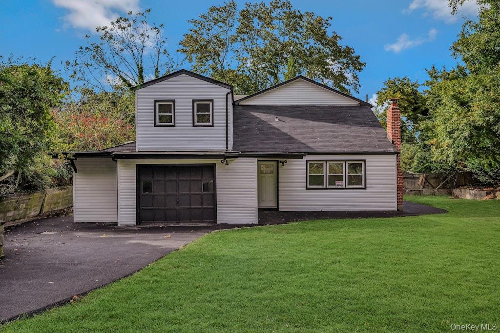a front view of a house with a garden and yard