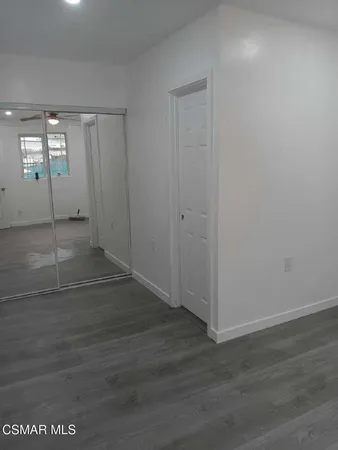 an empty room with wooden floor and mirror