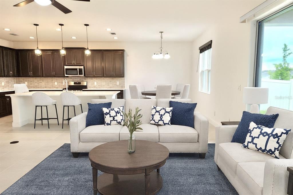 1193 Cavender Creek Road Minneola, FL 34715 - Photo 12 of 22 a living room with furniture kitchen view and a wooden floor