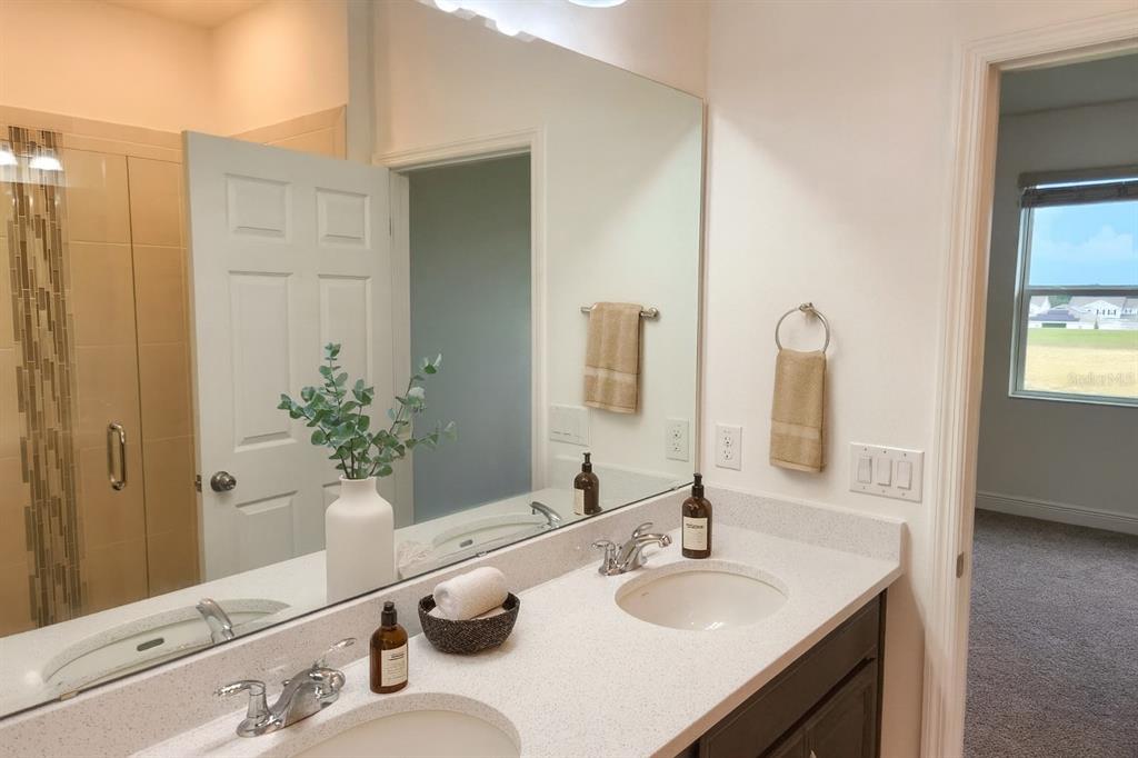1193 Cavender Creek Road Minneola, FL 34715 - Photo 13 of 22 a bathroom with double vanity sinks and a mirror