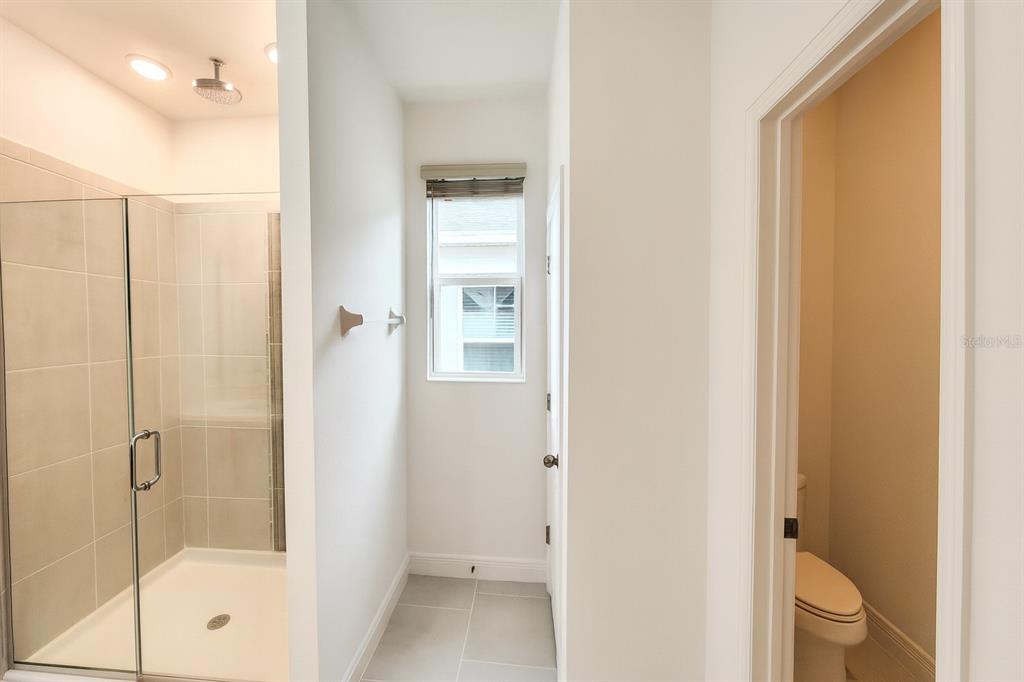 1193 Cavender Creek Road Minneola, FL 34715 - Photo 15 of 22 a bathroom with a glass shower door