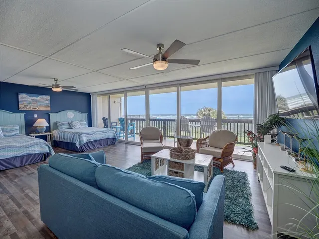 a living room with furniture large windows and a fireplace
