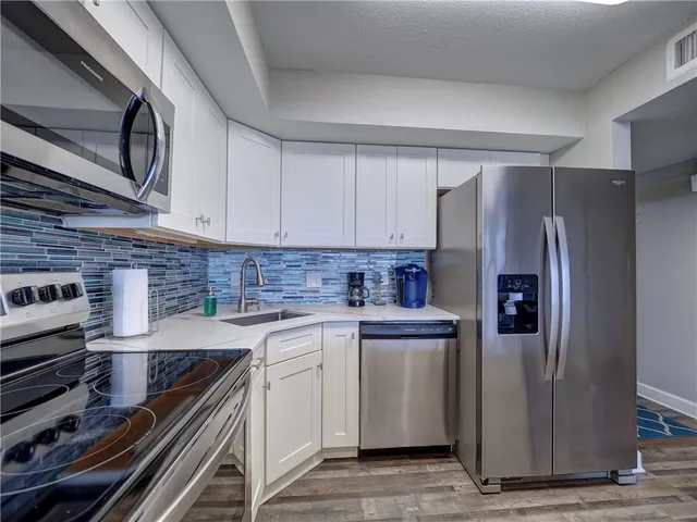a kitchen with stainless steel appliances granite countertop a refrigerator and a stove