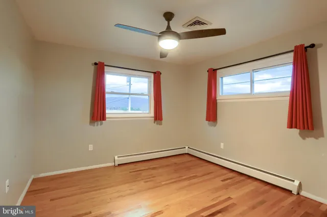 a view of empty room with wooden floor