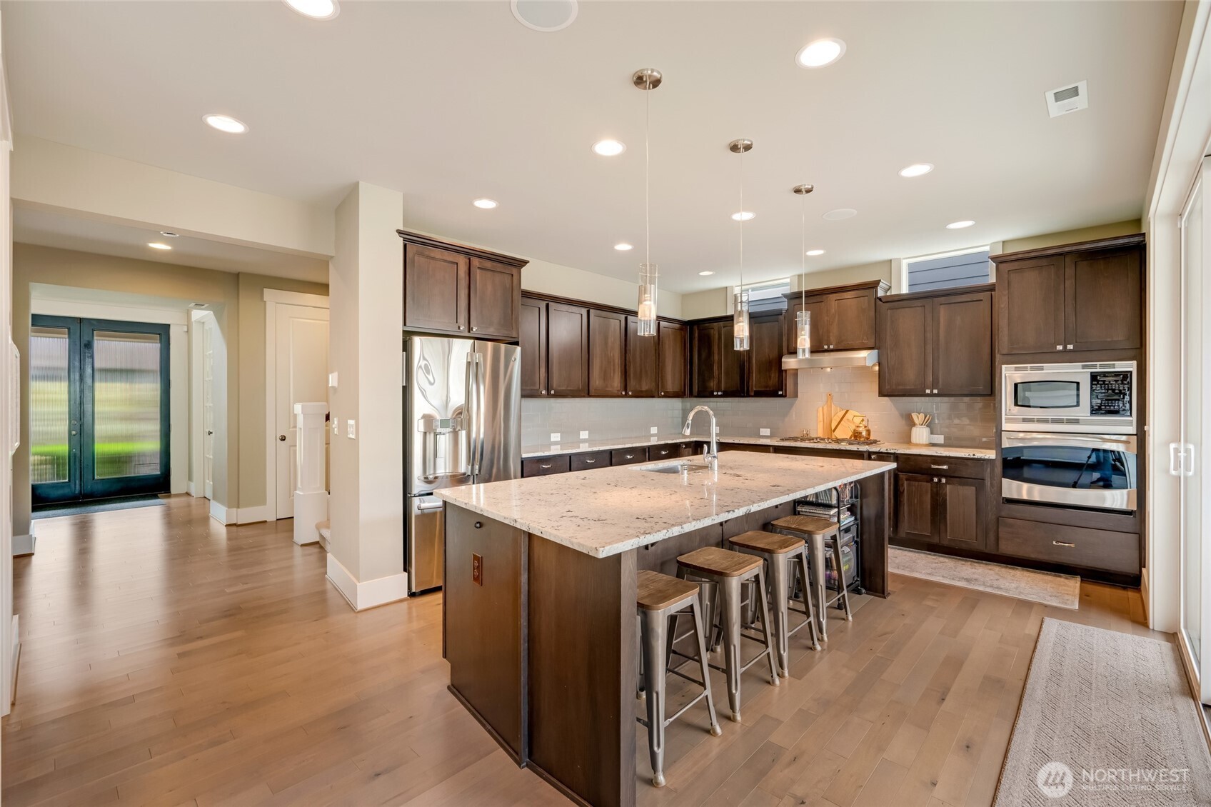 619 Graham Avenue Northeast Renton, WA 98059 - Photo 6 of 40 a kitchen with stainless steel appliances granite countertop a table chairs sink and refrigerator