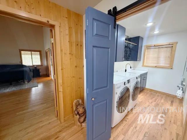 31 Rainbow Ridge Road Garden Valley, ID 83622 - Photo 13 of 33 Laundry area with light wood floors, independent washer and dryer, wood walls, sink, and cabinet space