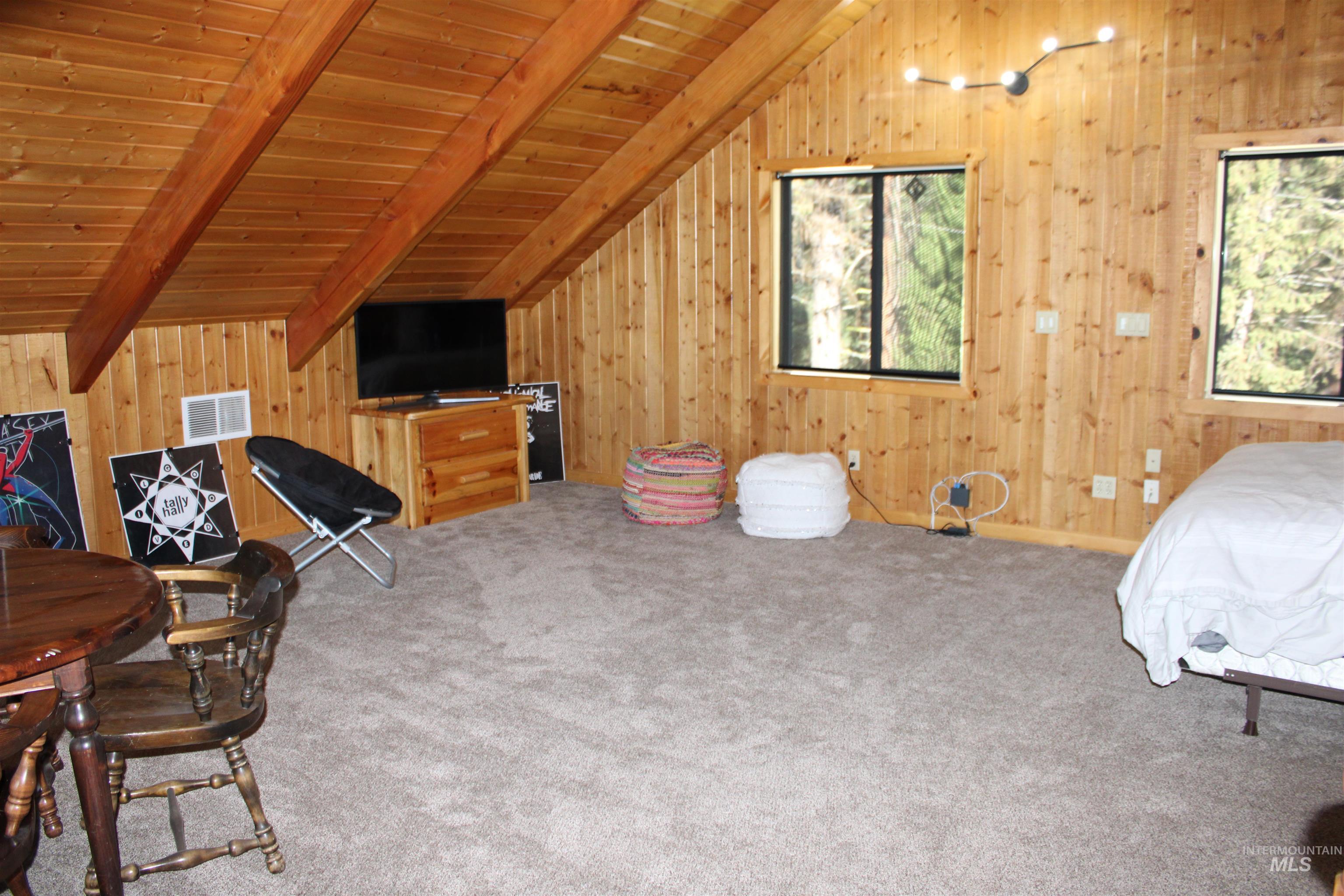 31 Rainbow Ridge Road Garden Valley, ID 83622 - Photo 14 of 33 Loft space with wooden walls, wood ceiling, vaulted ceiling with beams, ceiling fan and carpet flooring