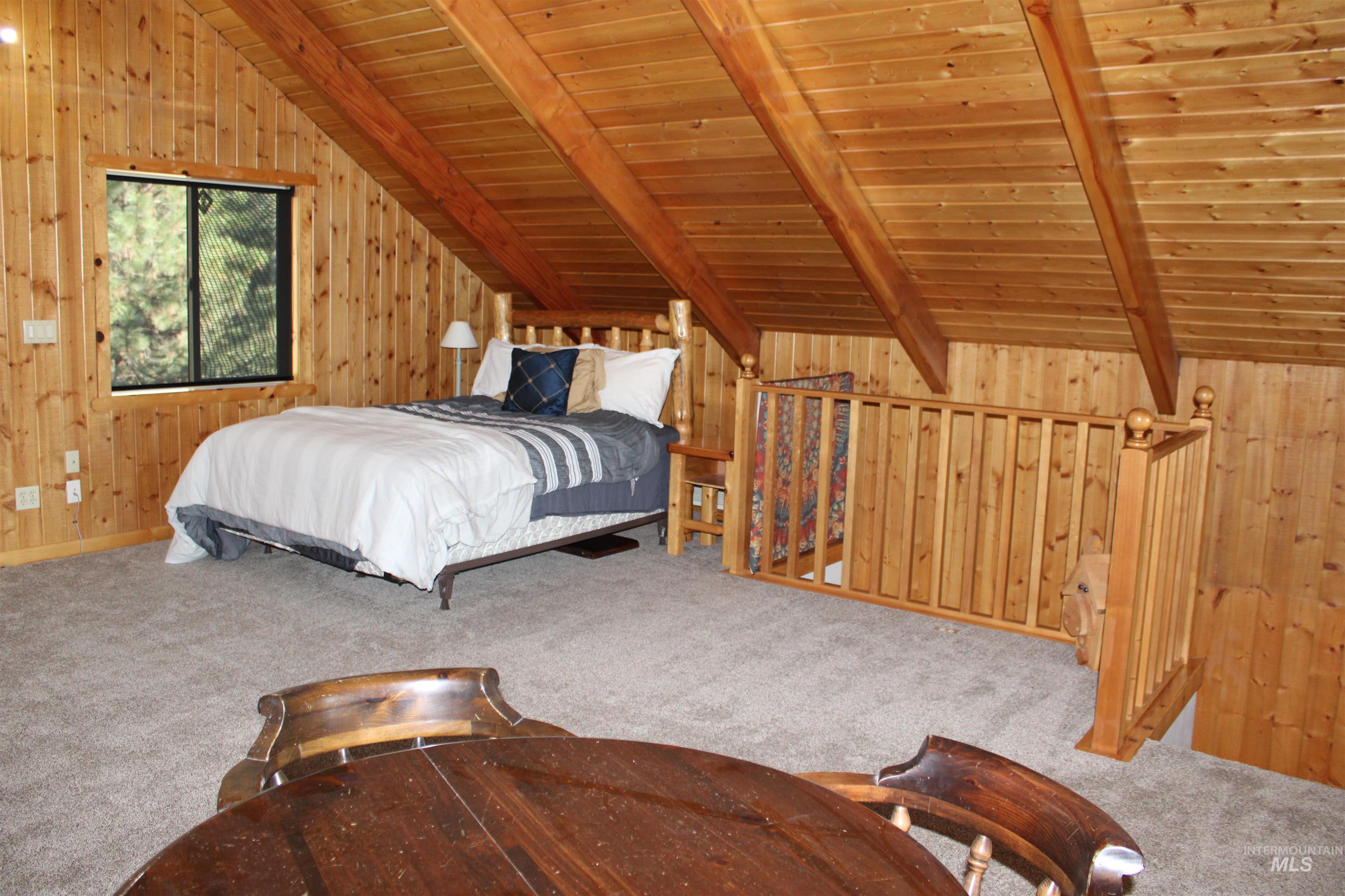 31 Rainbow Ridge Road Garden Valley, ID 83622 - Photo 15 of 33 Carpeted loft space with wood walls, wooden ceiling, ceiling fan and vaulted ceiling with beams