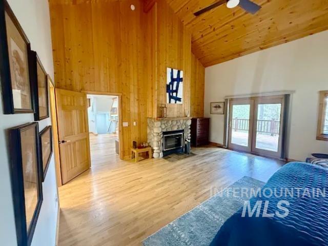 31 Rainbow Ridge Road Garden Valley, ID 83622 - Photo 17 of 33 Primary bedroom featuring wood flooring, a ceiling fan, wood walls, a fireplace, and sitting area
