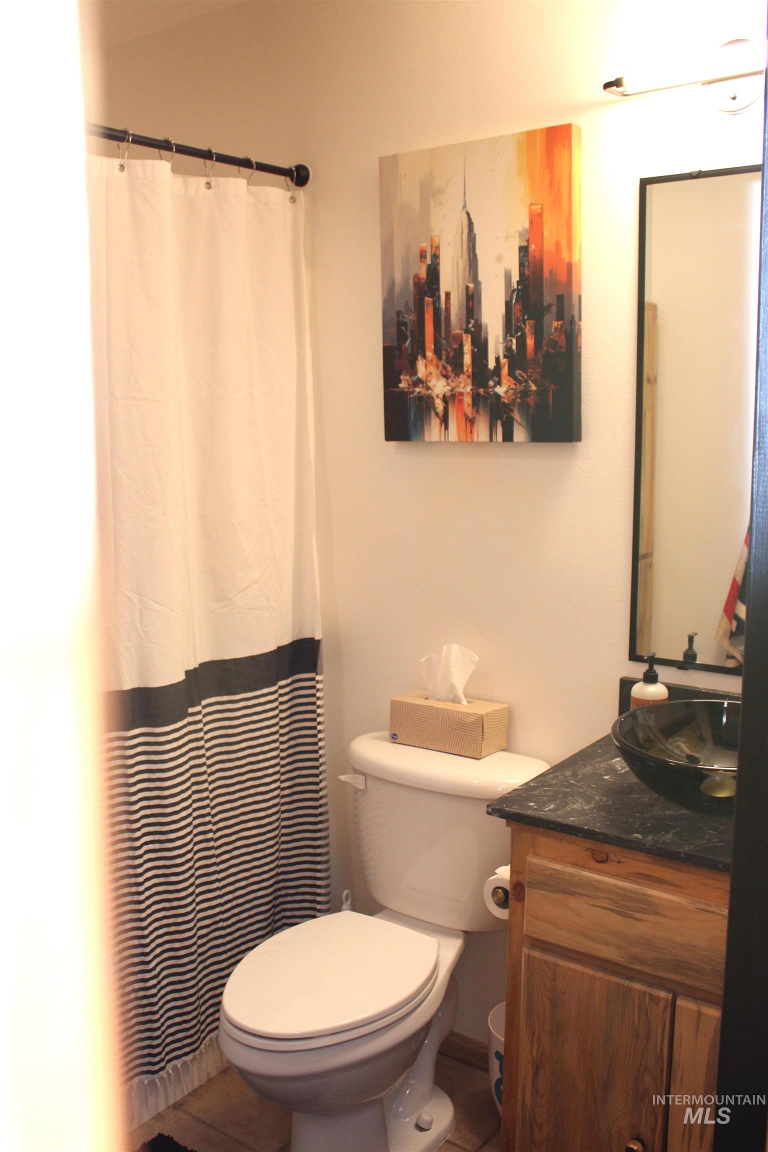 31 Rainbow Ridge Road Garden Valley, ID 83622 - Photo 23 of 33 Bathroom featuring vanity, a tub/shower with curtain, glass sink bowl and tile floor