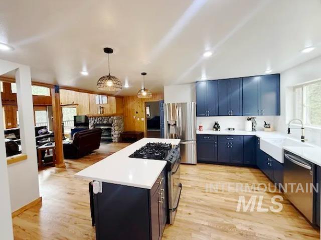 31 Rainbow Ridge Road Garden Valley, ID 83622 - Photo 33 of 33 Kitchen with quartz countertops, apron front sink, stainless steel appliances, a kitchen island, propane range, pantry, open floor plan, and light flooring
