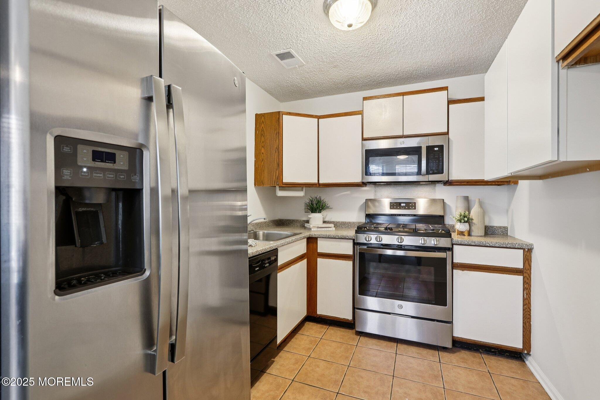 3015 Lighthouse Lane, Unit 3015 Parlin, NJ 08859 - Photo 11 of 22 a kitchen with stainless steel appliances granite countertop a stove a refrigerator and a microwave