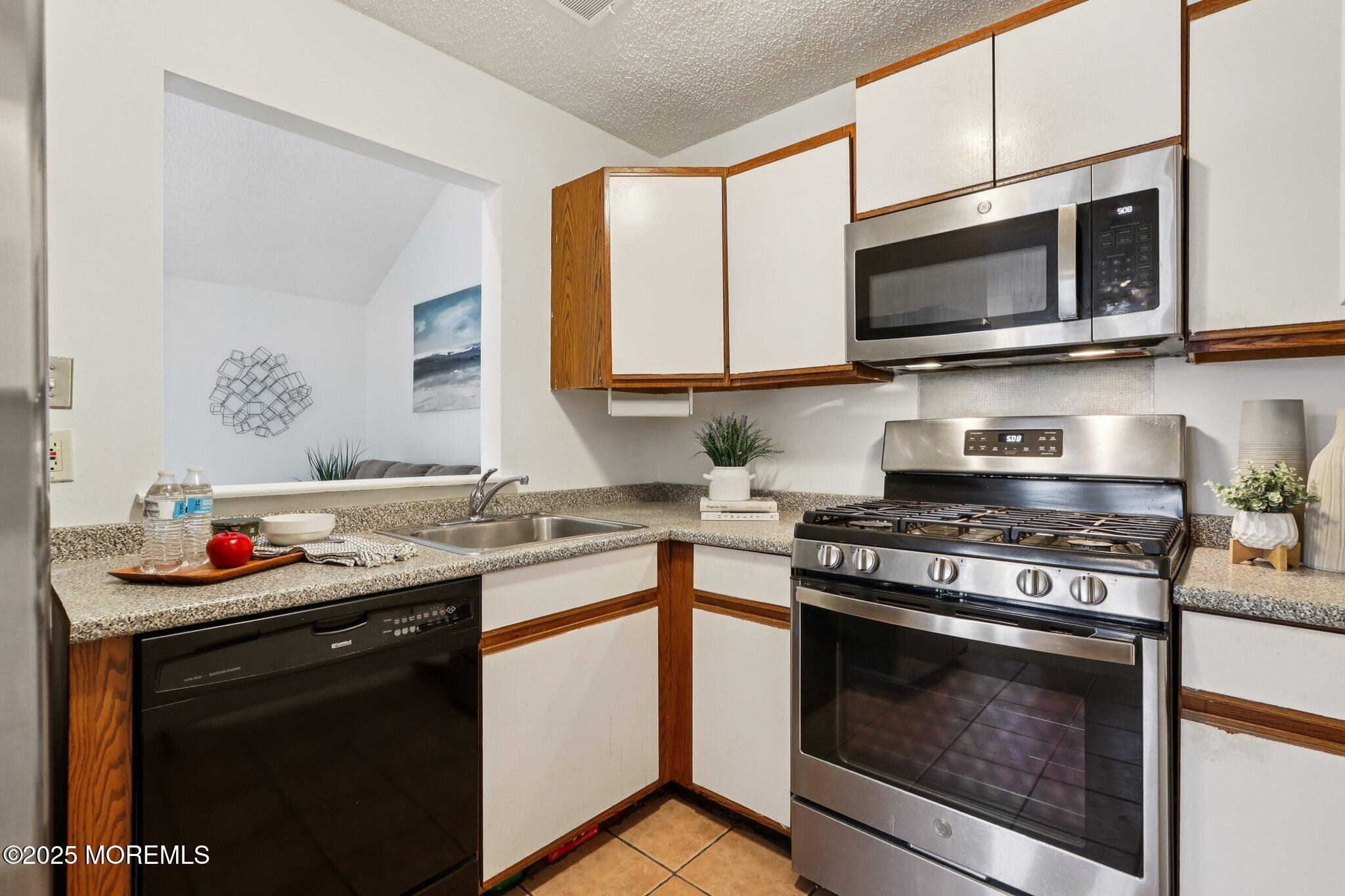 3015 Lighthouse Lane, Unit 3015 Parlin, NJ 08859 - Photo 12 of 22 a kitchen with stainless steel appliances granite countertop a sink stove top oven and microwave