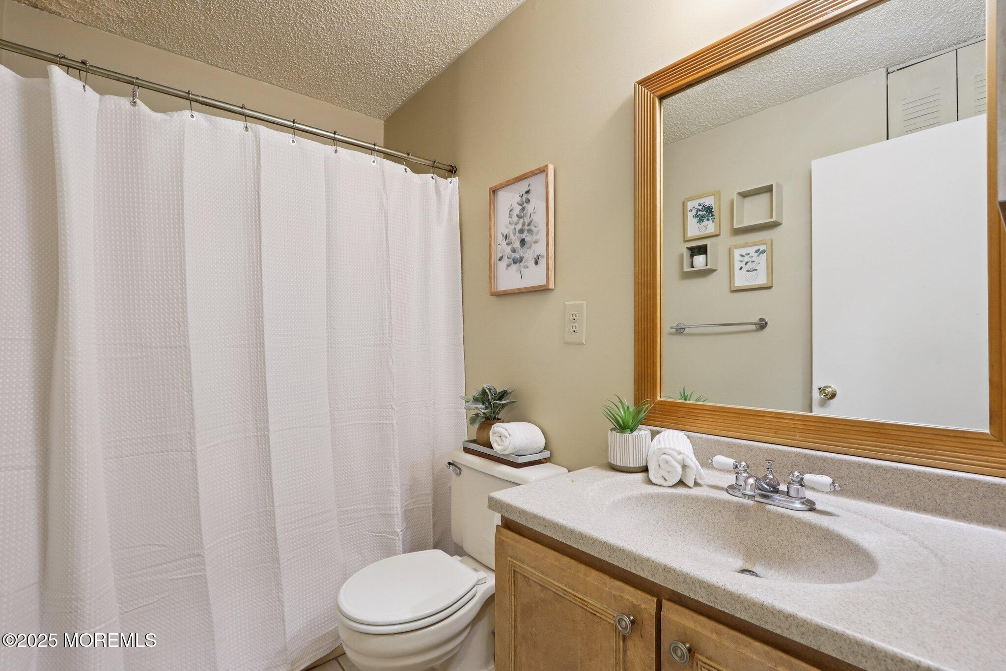 3015 Lighthouse Lane, Unit 3015 Parlin, NJ 08859 - Photo 19 of 22 a bath room with a sink a toilet and a mirror