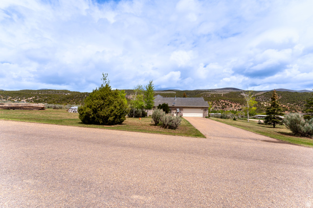 7343 North Sawtooth Cv Road Vernal, UT 84078 - Photo 57 of 64 Ranch-style exterior with a front-facing garage, asphalt driveway, and a shingle roof