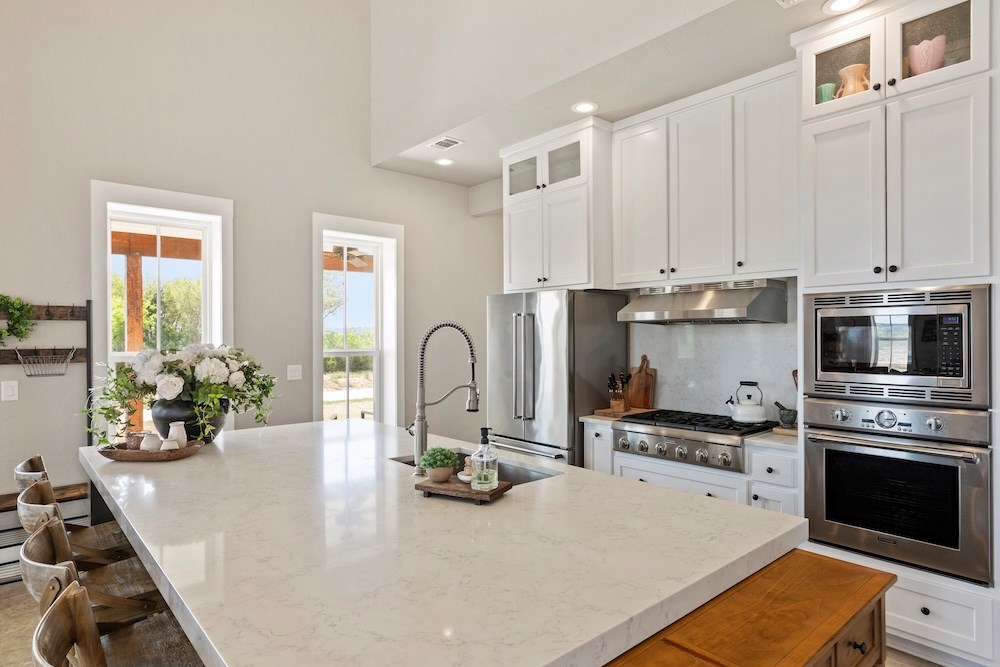 792 Langes Mill Road Doss, TX 78618 - Photo 24 of 76 a kitchen with stainless steel appliances a stove a sink a microwave a refrigerator and cabinets