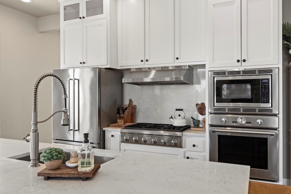 792 Langes Mill Road Doss, TX 78618 - Photo 25 of 76 a kitchen with stainless steel appliances granite countertop a stove a microwave and cabinets