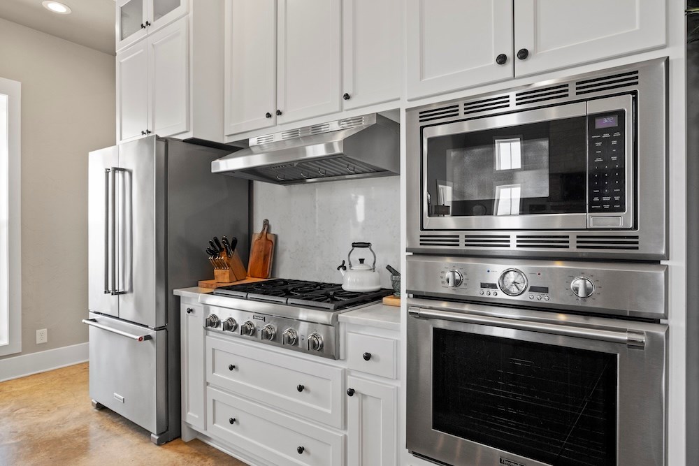 792 Langes Mill Road Doss, TX 78618 - Photo 26 of 76 a kitchen with stainless steel appliances granite countertop a stove and a microwave