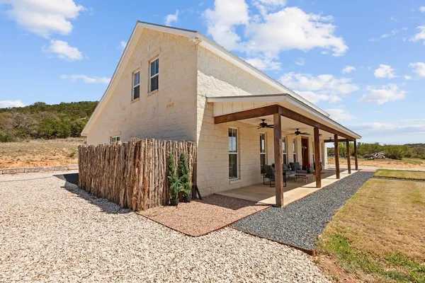 a living room with furniture kitchen view and a large window