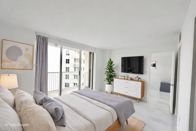 a bedroom with a bed a television and wooden floor