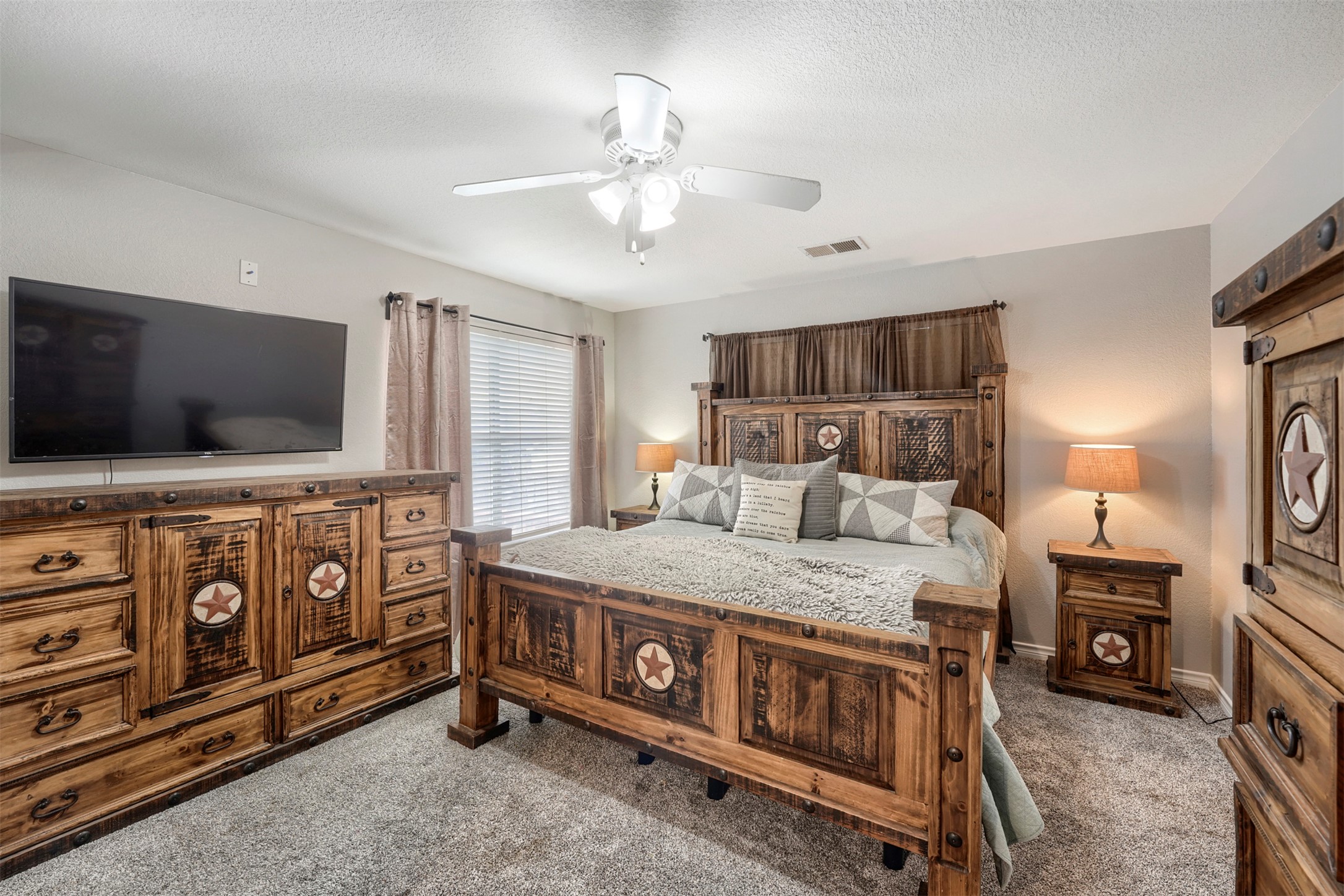 1105 2nd Street Jarrell, TX 76537 - Photo 12 of 27 A well-lit bedroom features plush carpeting and a classic ceiling fan, providing comfort and style.