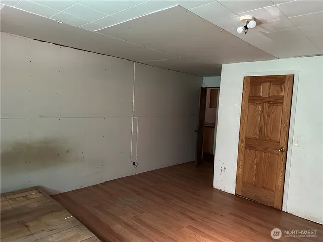 an empty room with wooden floor and closet