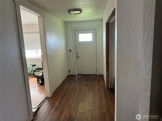 a view of a hallway with wooden floor and stairs