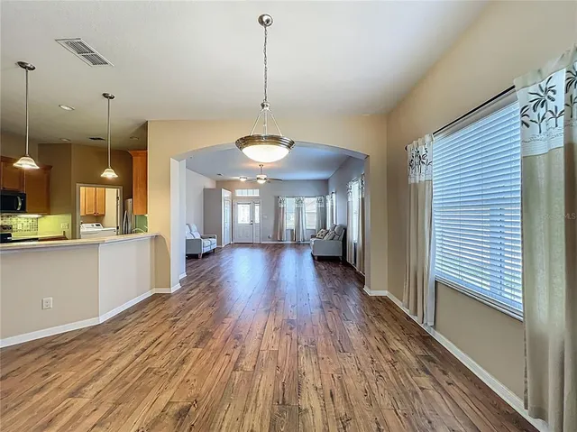 a view of a room with wooden floor and large windows