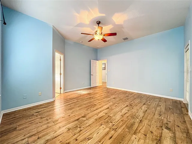 a view of an empty room with window and wooden floor