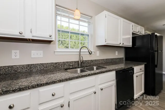 a kitchen with granite countertop a sink and a stove