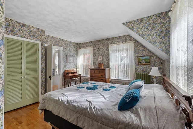 a bedroom with a large bed and large windows