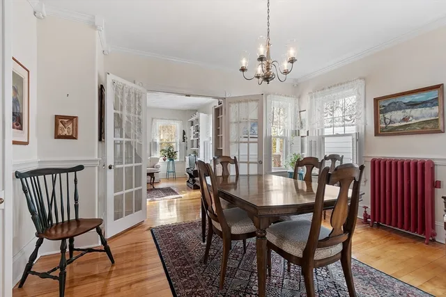 a view of a a dining room with furniture a chandelier and wooden floor