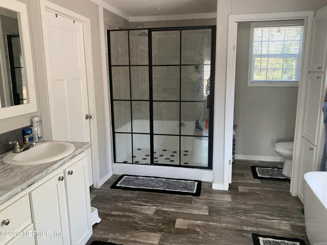 a bathroom with a sink a mirror and a shower